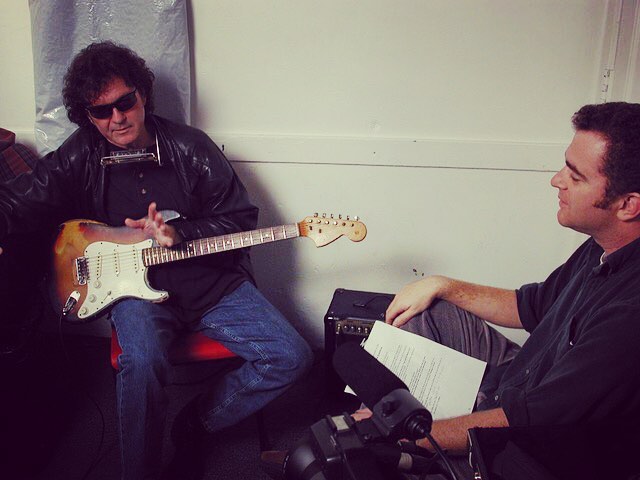 tony joe wearing sunglasses and harmonica white holding bass guitar sitting with ric stewart 2002